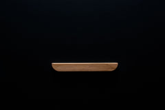 Unfinished oak cabinet handle on black background