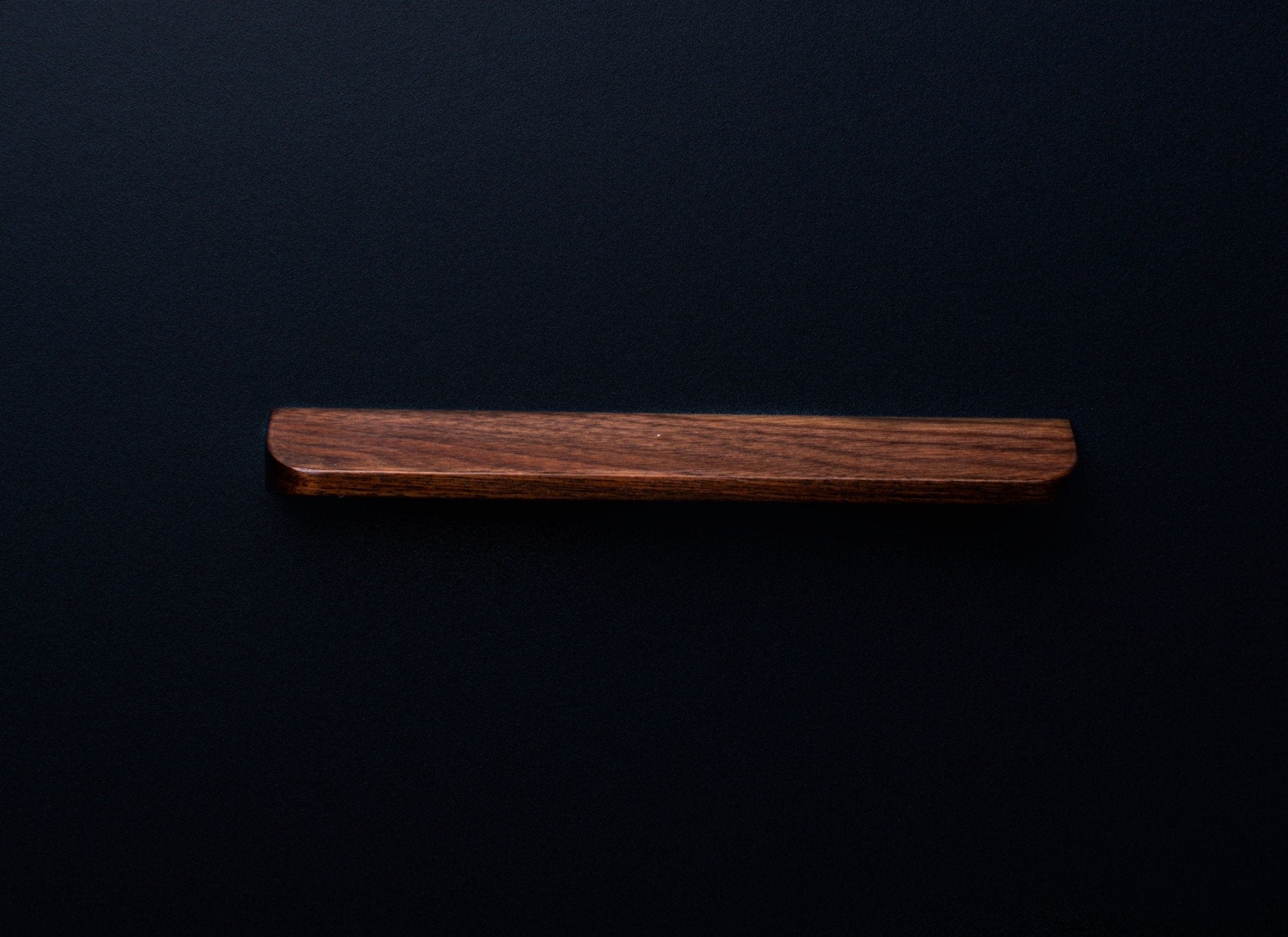 Front view of a rectangular American walnut cabinet handle with a rich dark brown finish