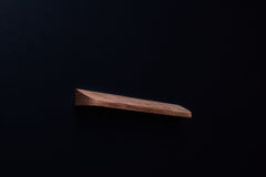 Side profile of an unfinished American walnut handle with visible grain and bevel