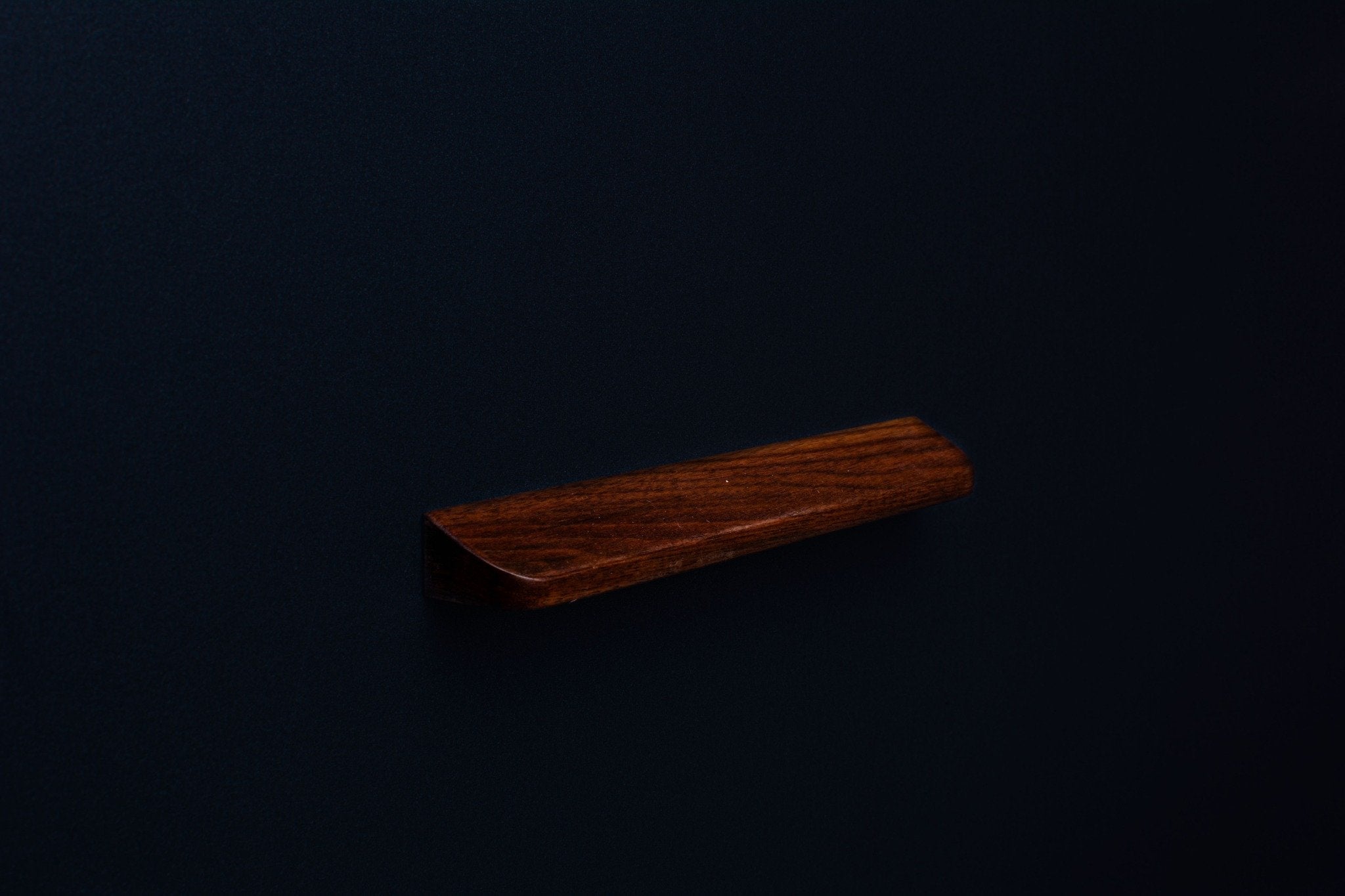 Top corner perspective of an American walnut wood handle showing natural grain and rounded edge