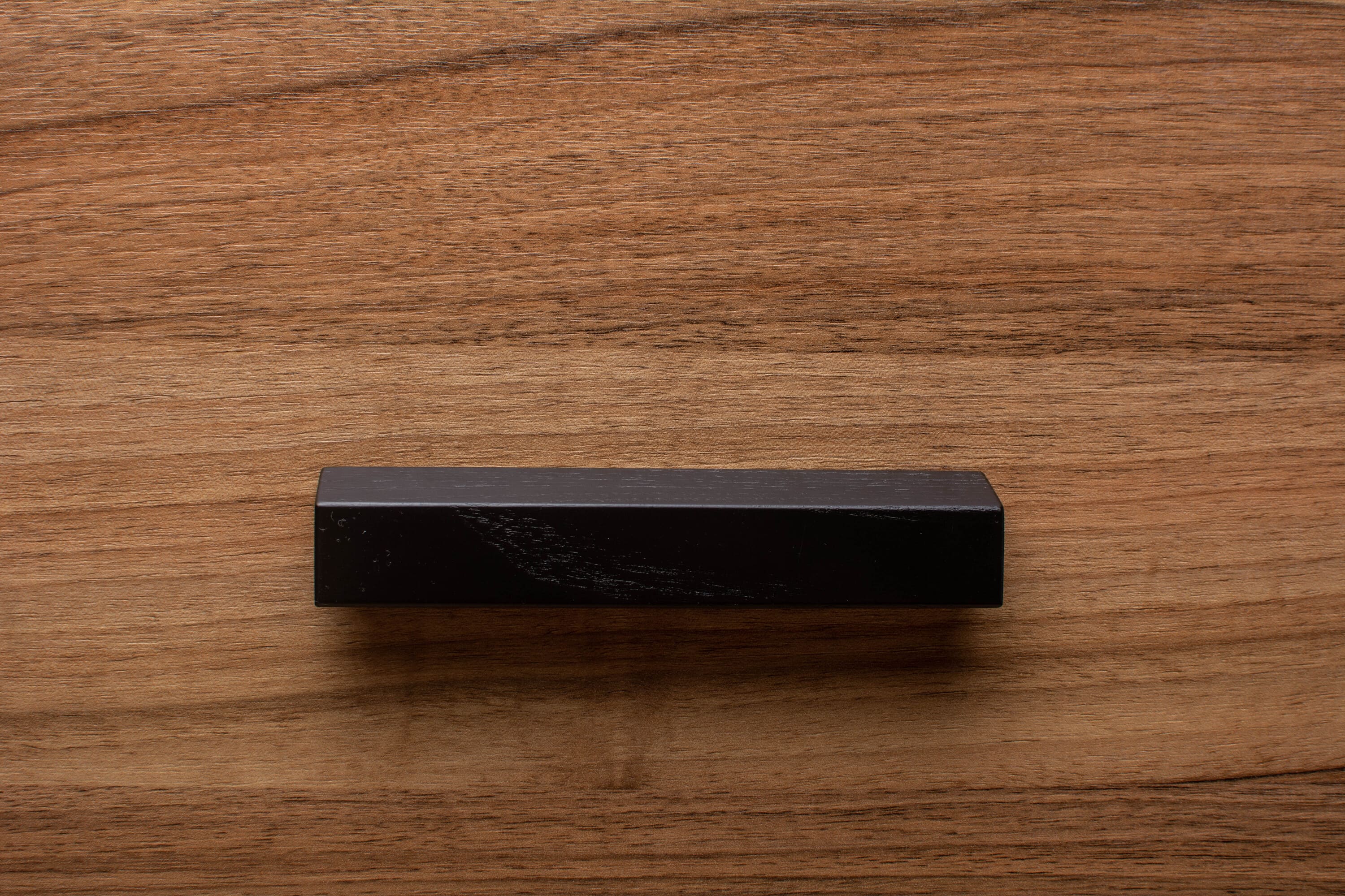 Black classic handle installed on walnut cabinet, perfect for traditional and modern interiors.