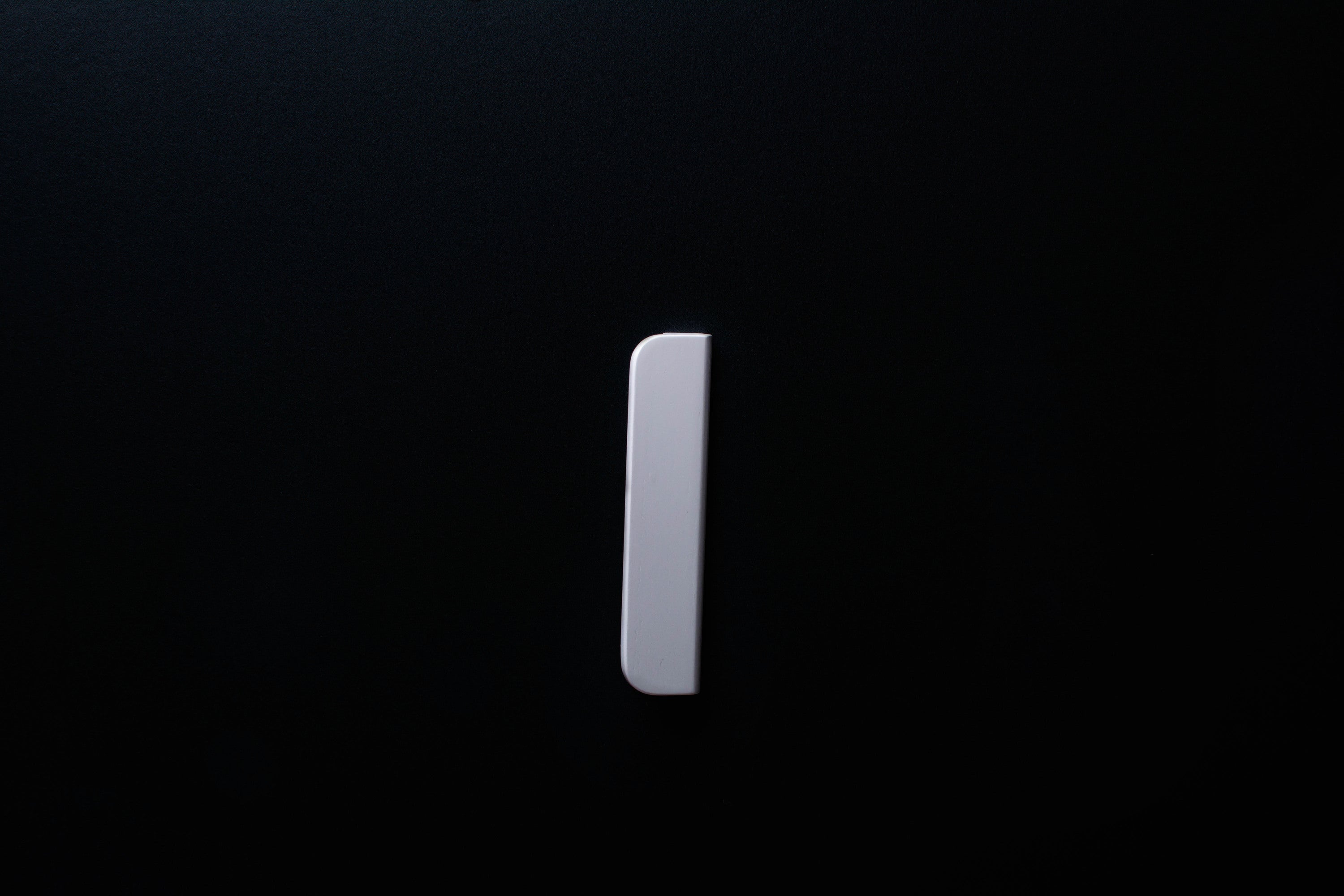 White Wooden drawer  handle in vertical position with detailed view on grip