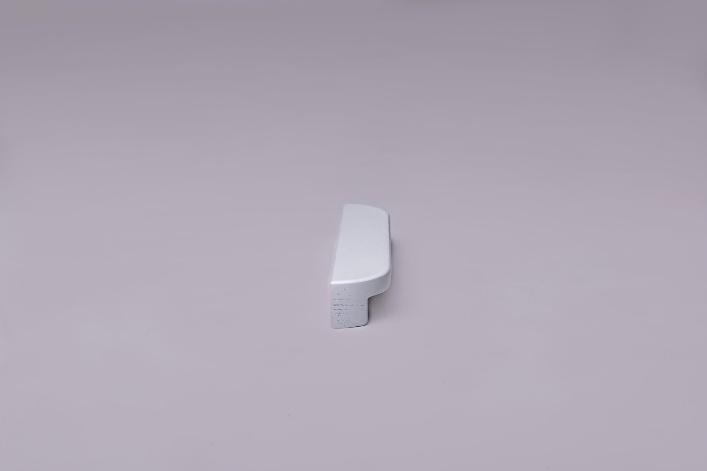Classic Rounded White Cabinet Handle on grey