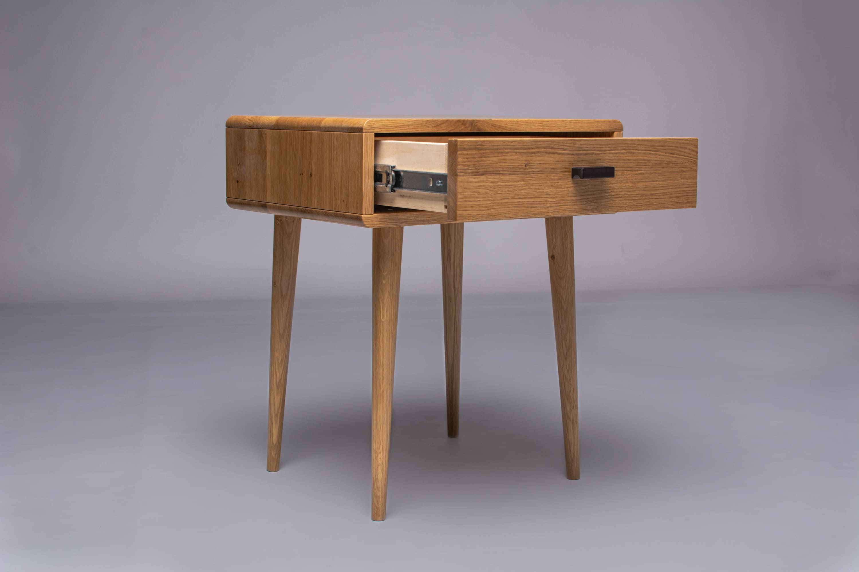 Assembled oak nightstand with rounded edges and matte finish.