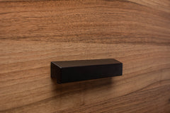 Elegant black wooden handle on walnut cabinet, enhancing the timeless look of the furniture.