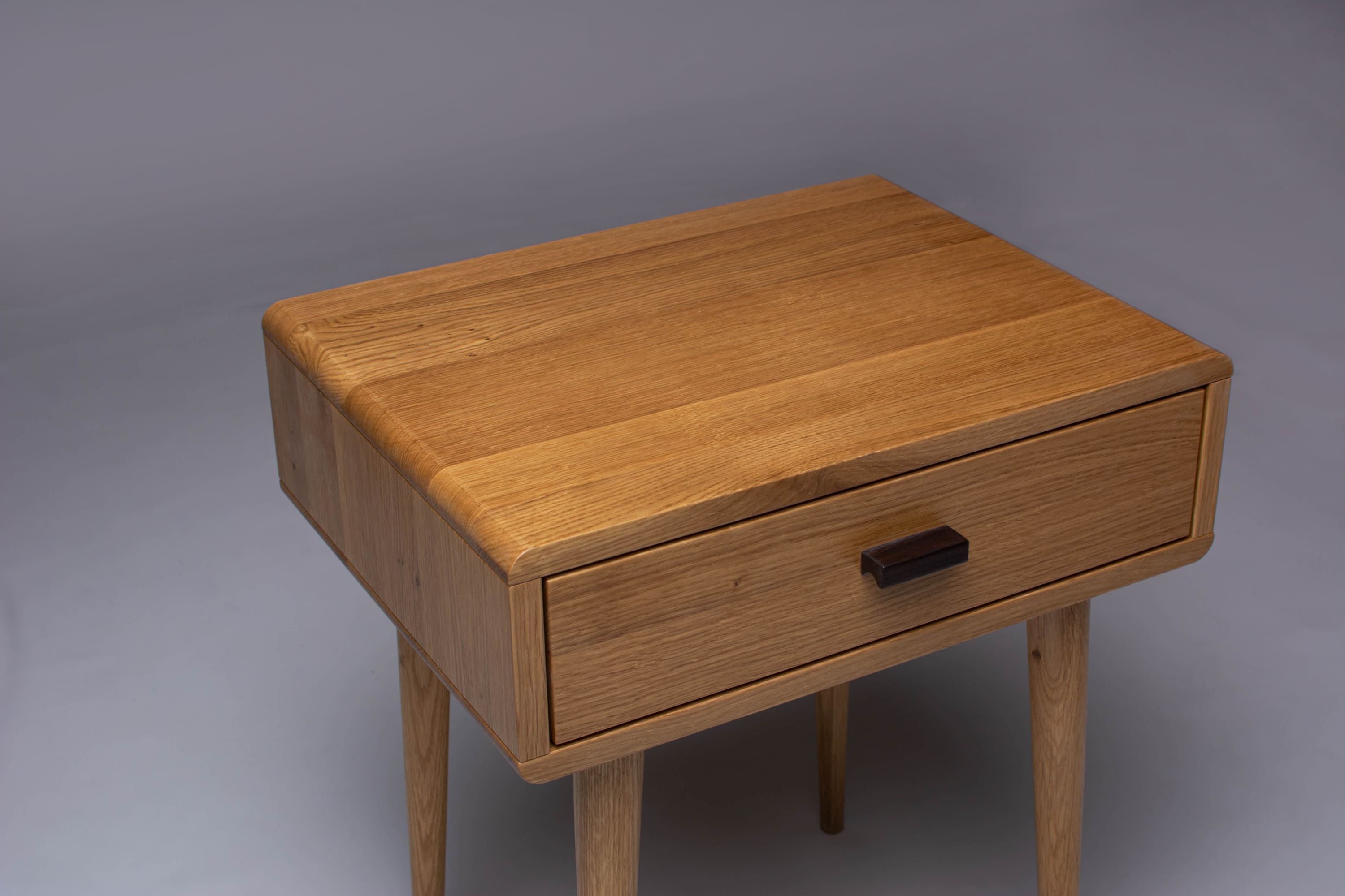 Close-up of oak wood grain on a modern bedside table.