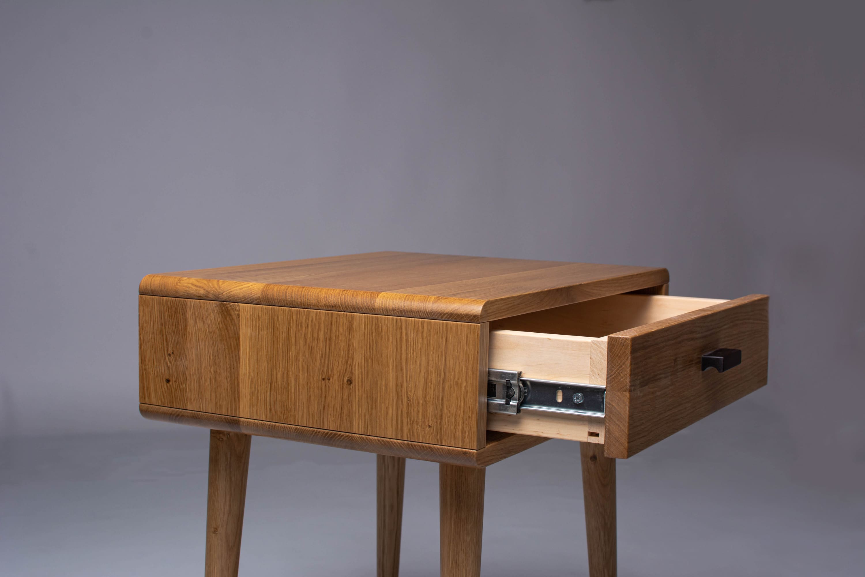 Spacious drawer of Mid-Century oak nightstand, open view