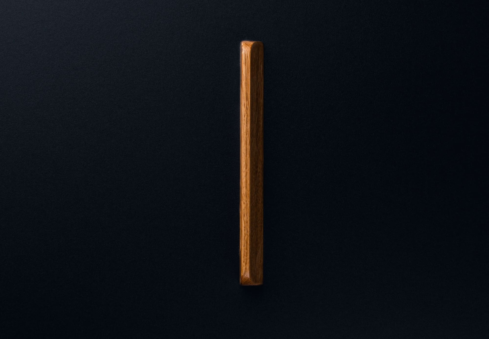 Symmetrical oak drawer handle in matte finish, close frontal perspective