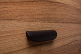 Modern black rounded handle on walnut cabinet, adding a sleek and contemporary touch.