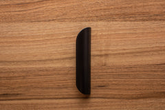 Minimalist rounded black handle on walnut cabinet, offering a modern and polished look.