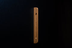 Close-up of light oak handle without finish, installed on dark cabinet