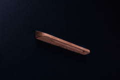 Back view of a raw American walnut handle showing screw hole and ergonomic curve