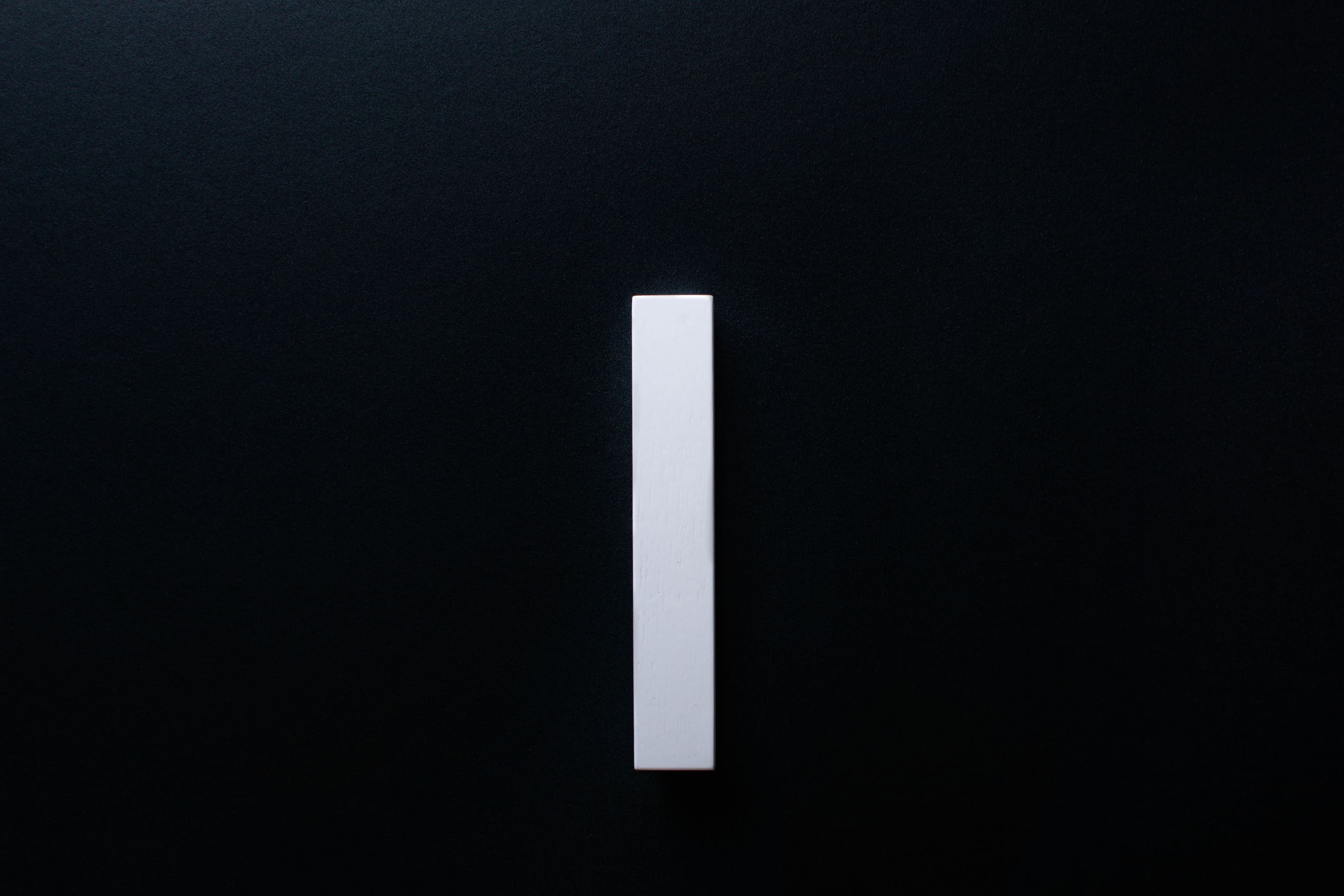 White Wooden drawer  handle in vertical position with detailed view on grip