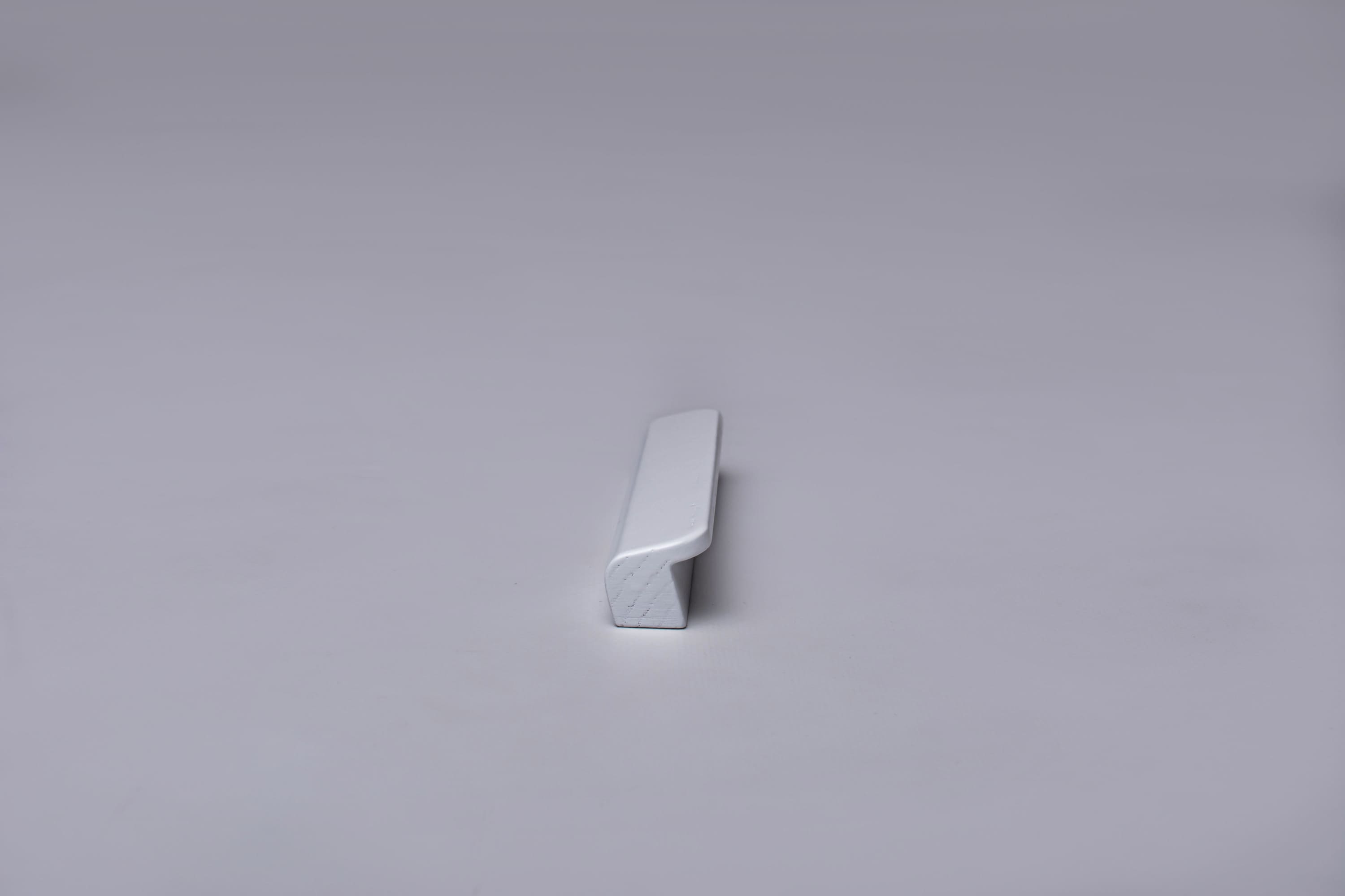 Classic Rounded White Cabinet Handle on grey