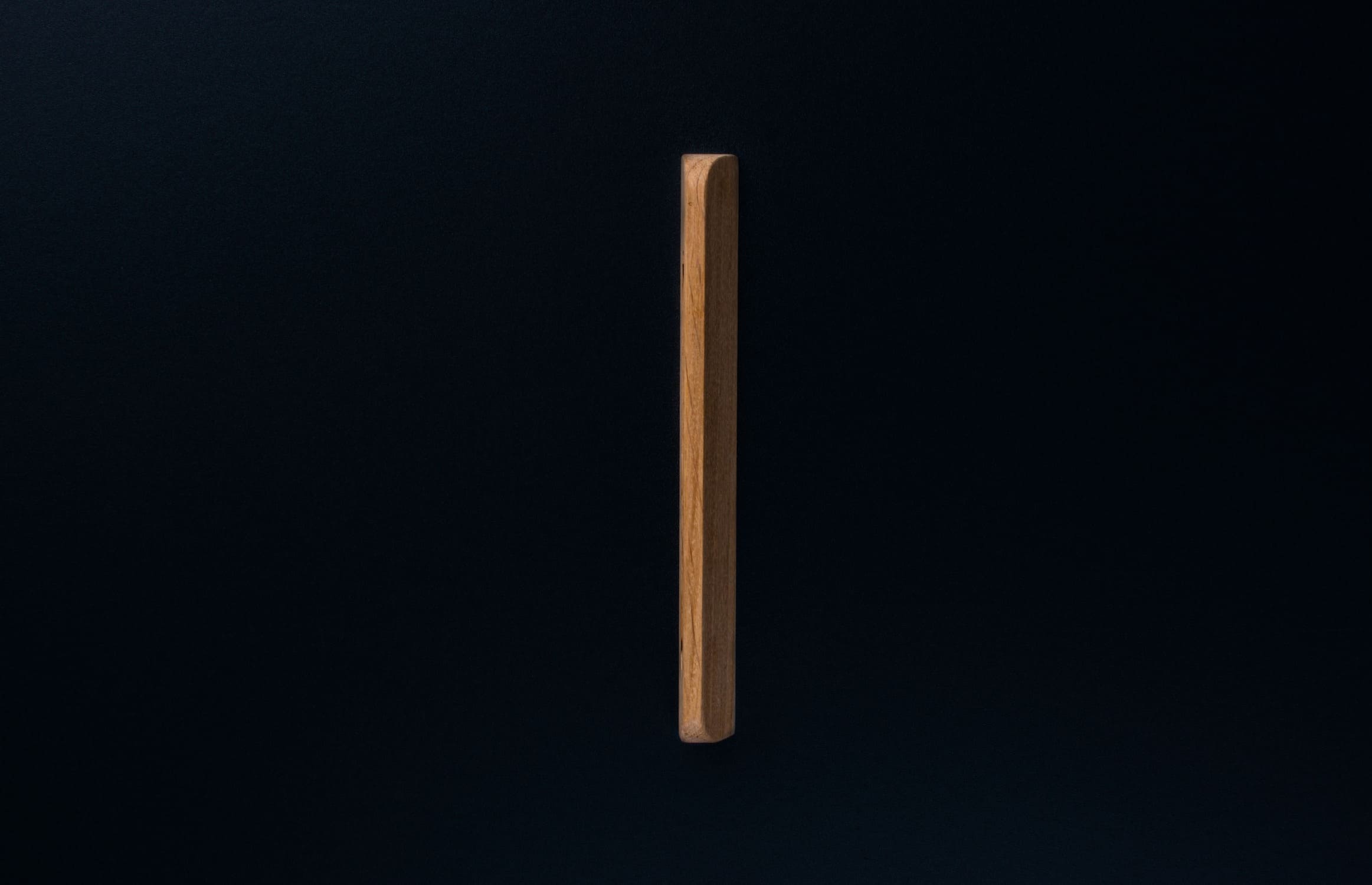 Wide-angle shot of raw oak cabinet handle mounted horizontally