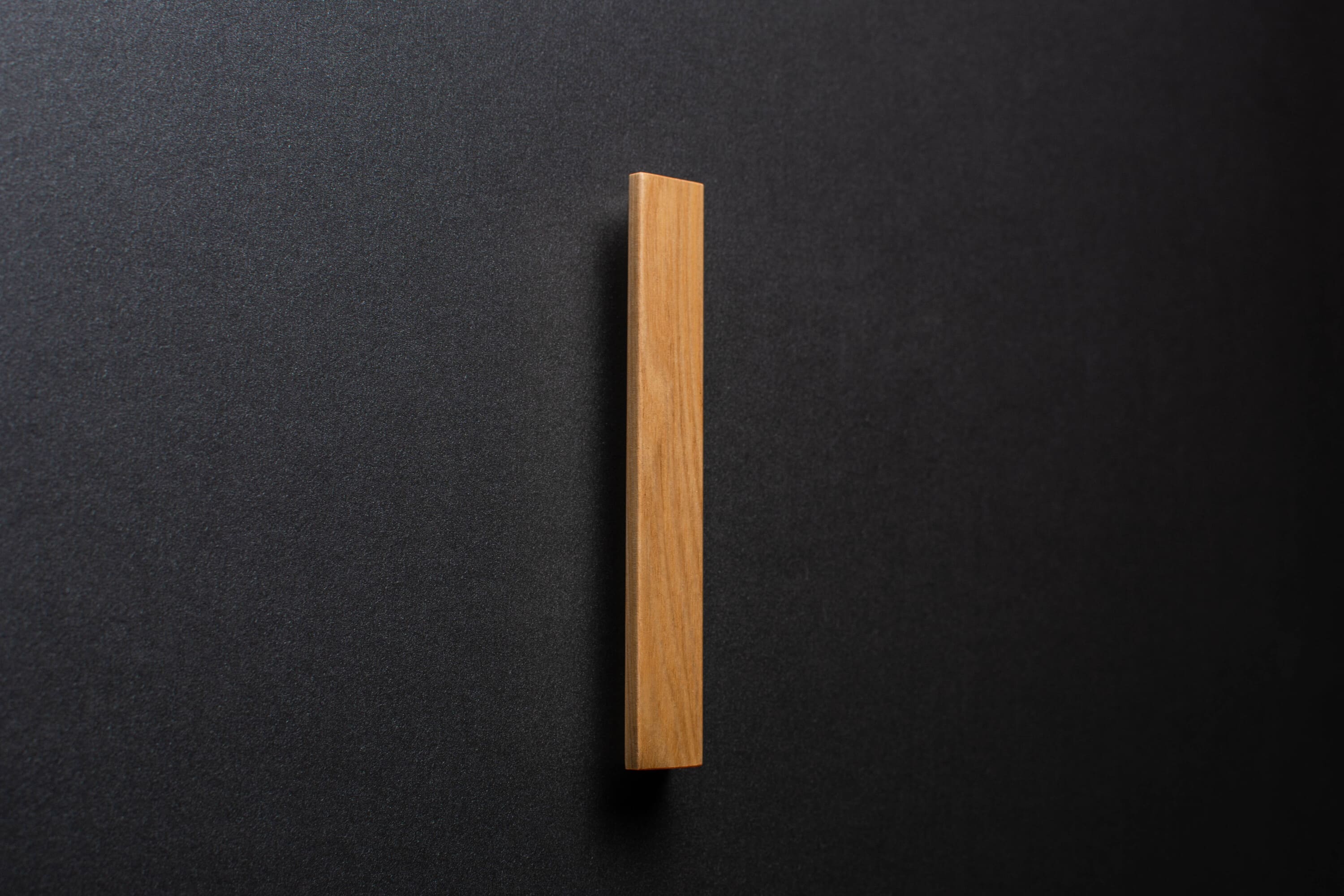 Wooden drawer ash handle in vertical position with detailed view on grip