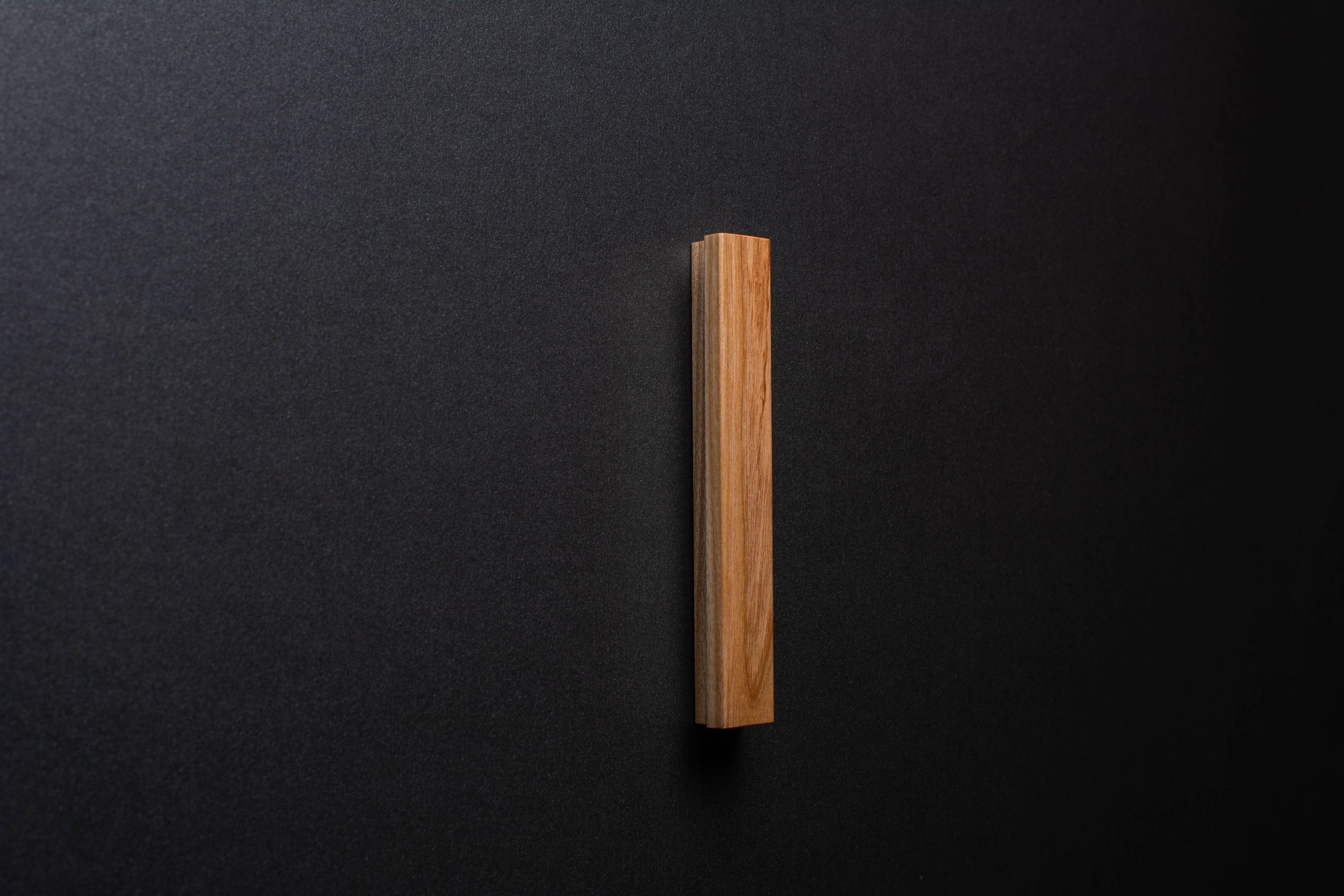 Wooden drawer ash handle in vertical position with detailed view on grip