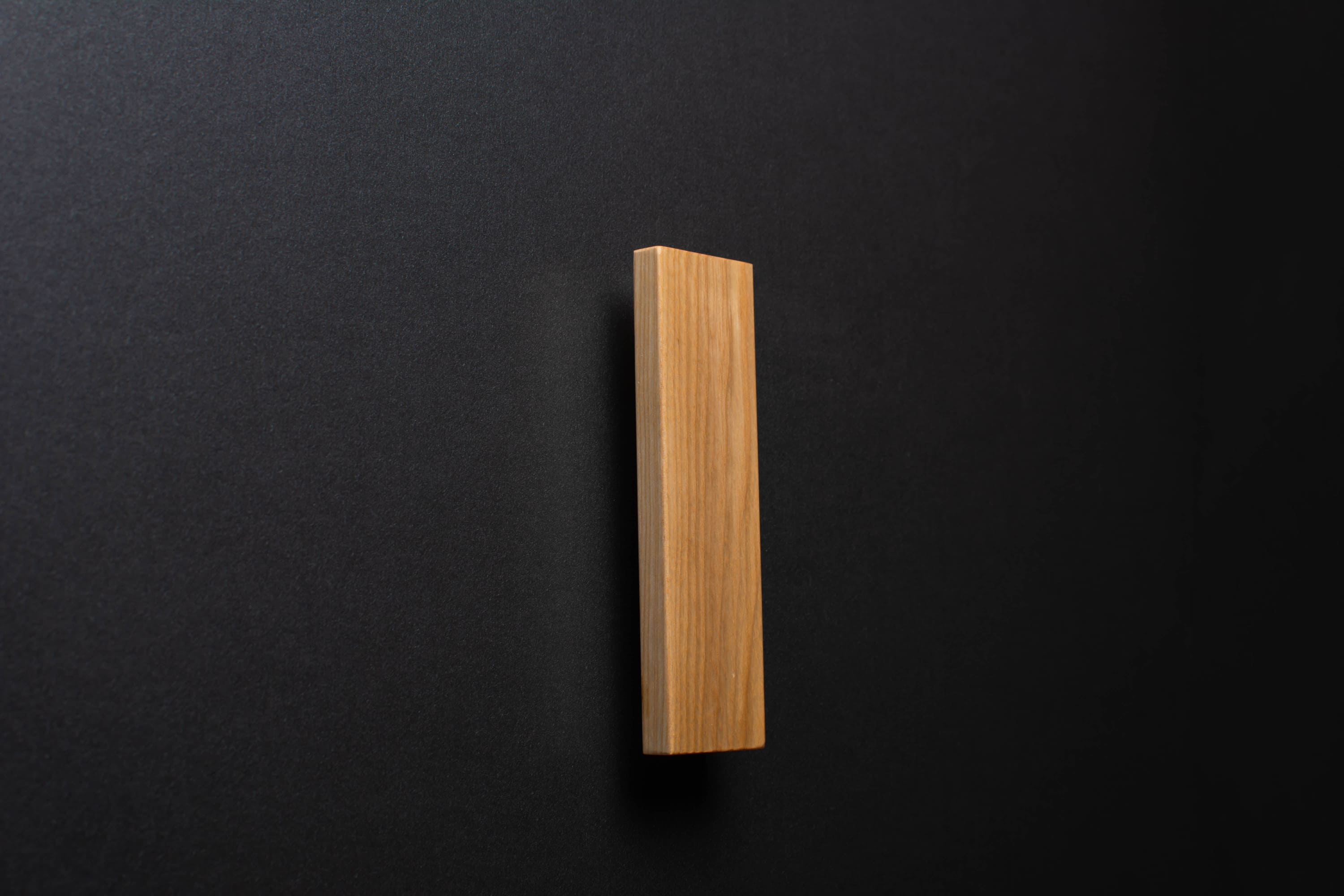 Wooden drawer ash handle in vertical position with detailed view on grip