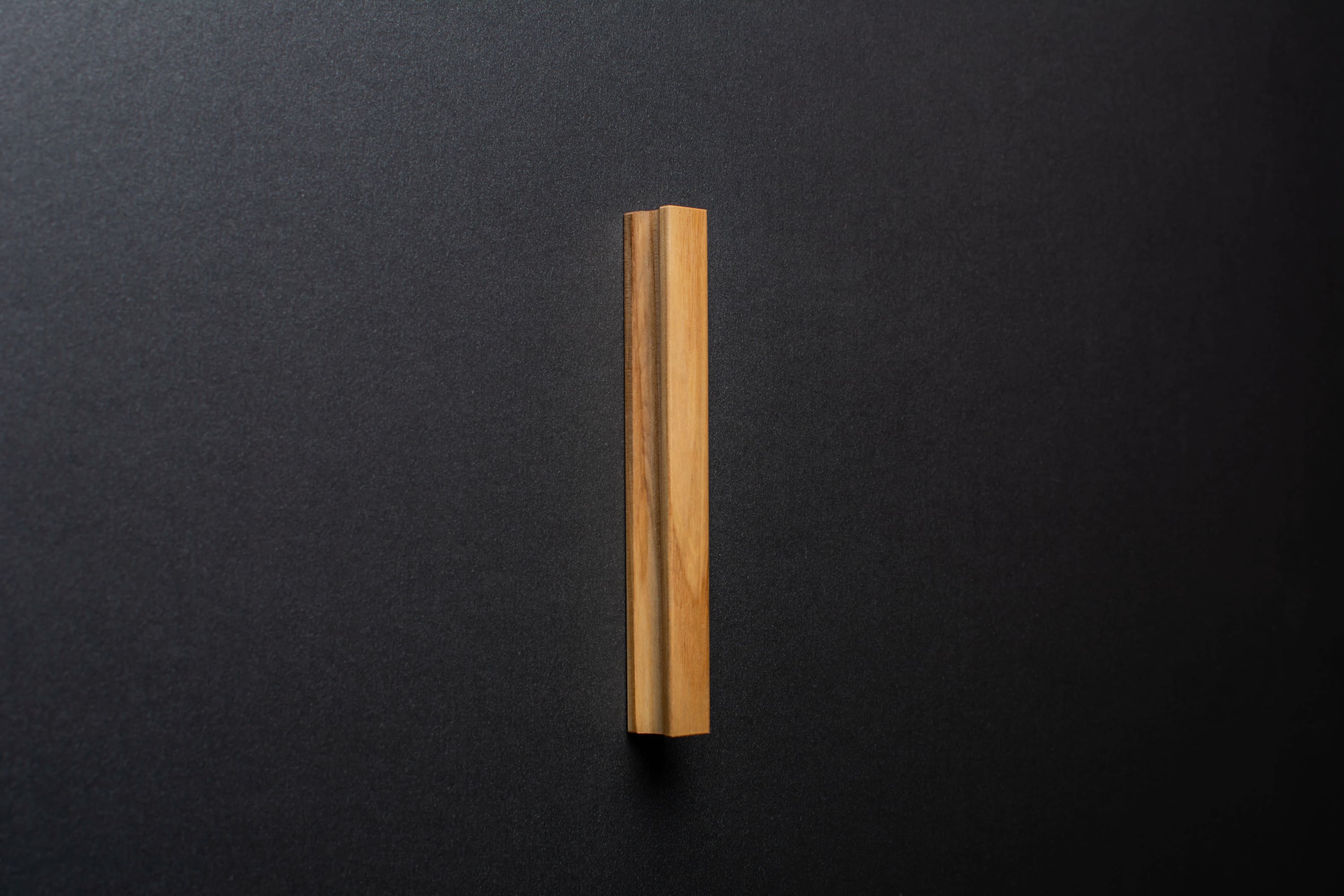 Wooden drawer ash handle in vertical position with detailed view on grip