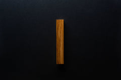 Angled view of the Modern Oak Cabinet Handle mounted on a black cabinet, capturing the natural oak texture.