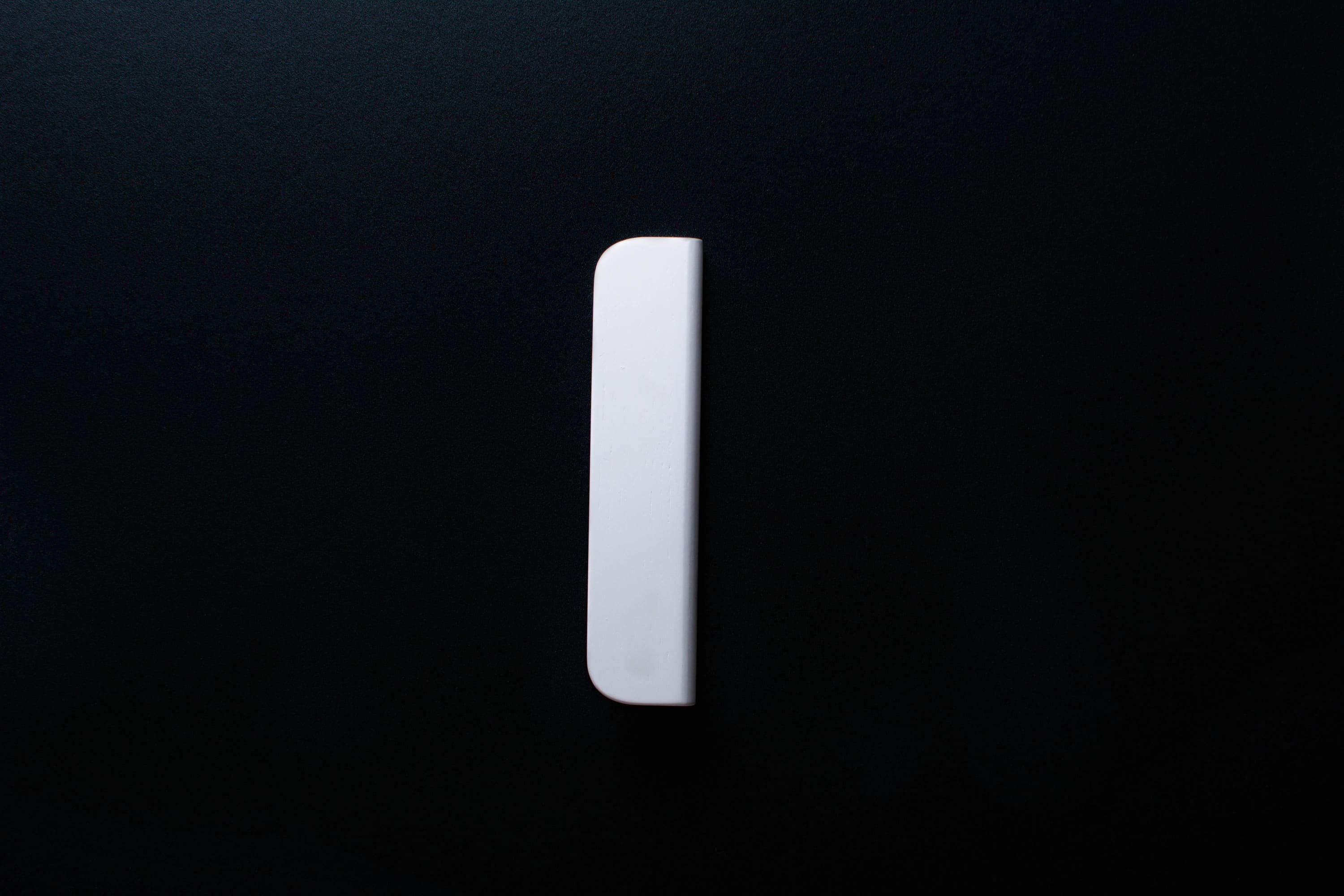 White Wooden drawer  handle in vertical position with detailed view on grip