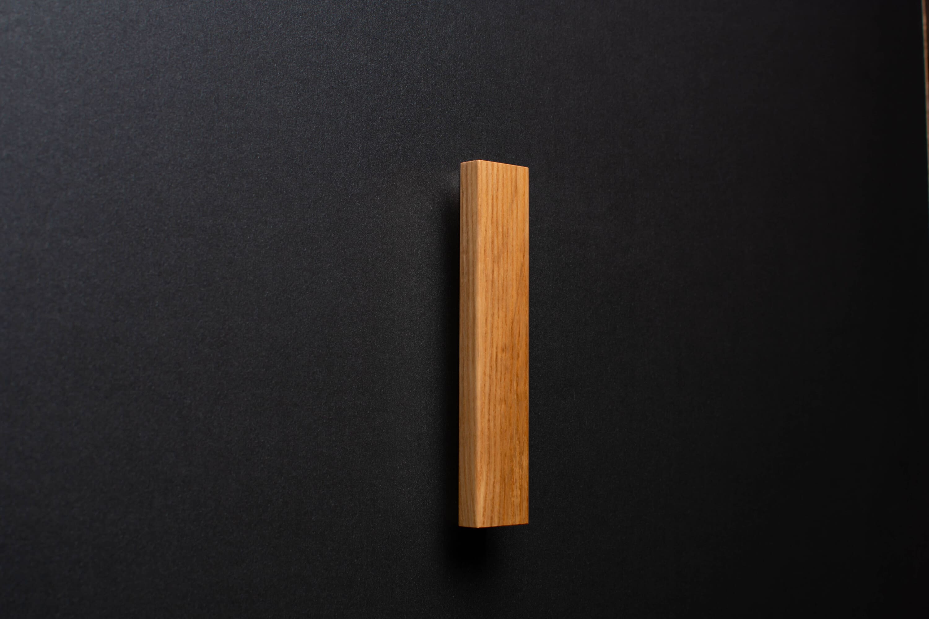 Wooden drawer ash handle in vertical position with detailed view on grip