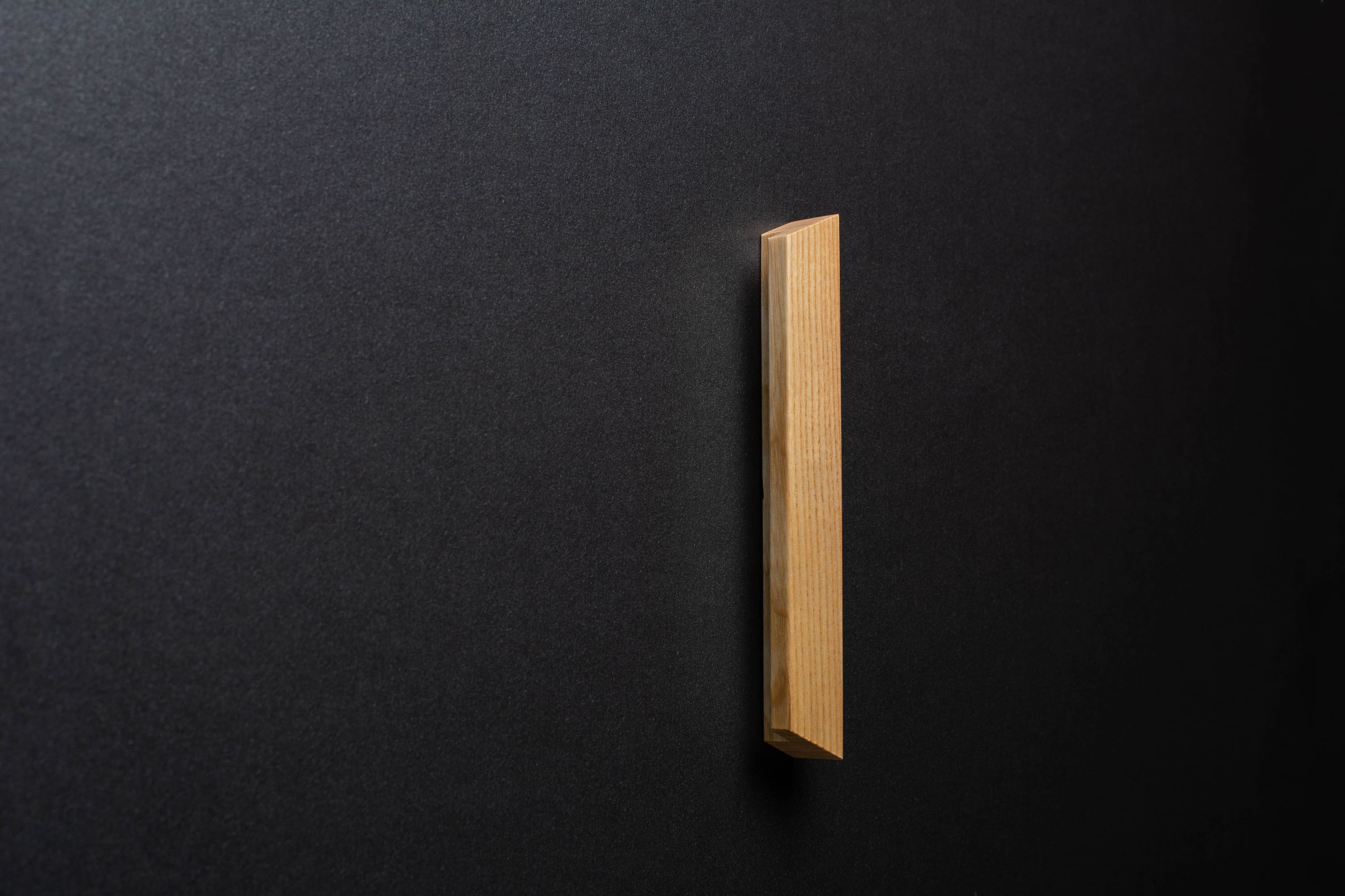 Wooden drawer angled ash handle in vertical position with detailed view on grip