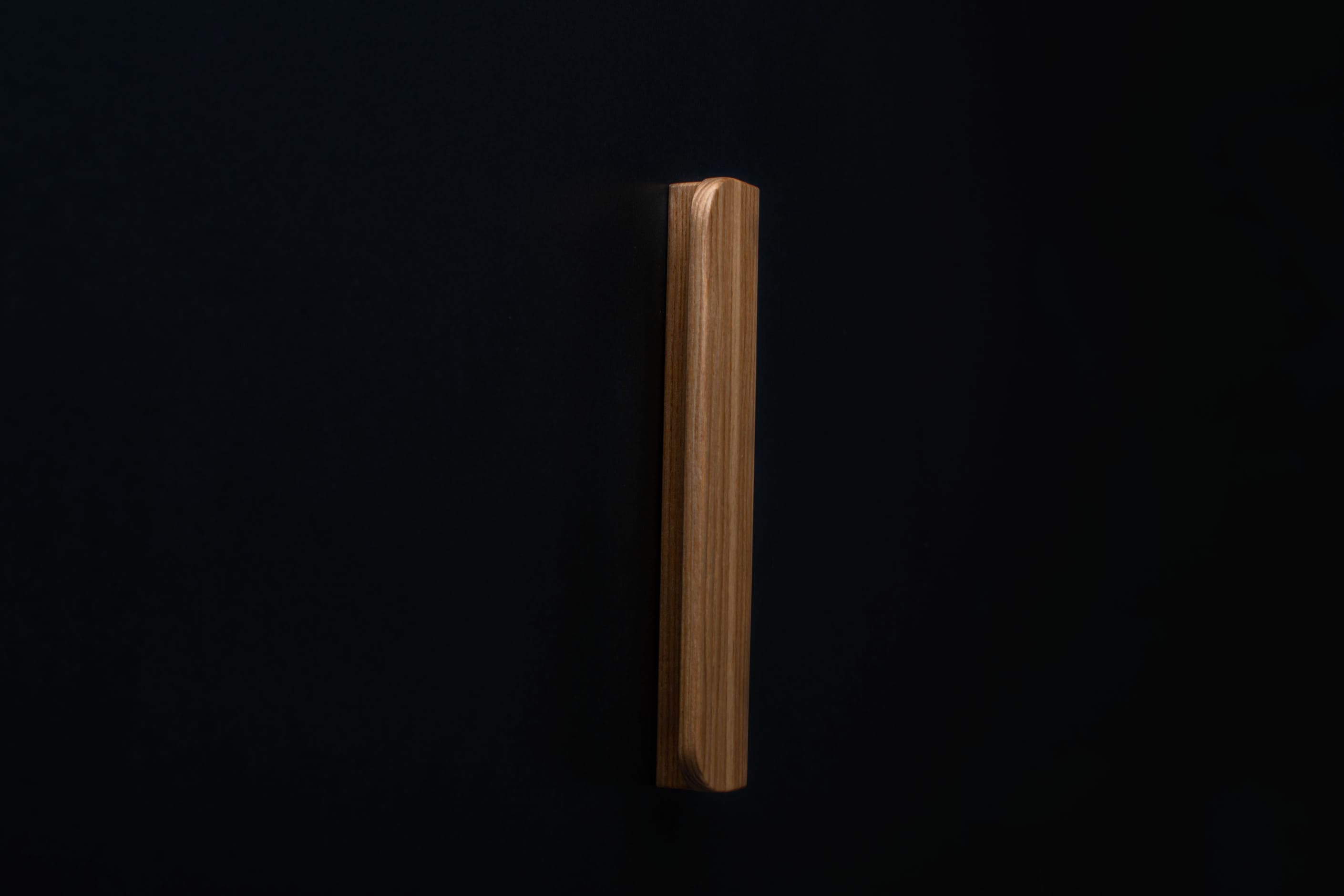 Wooden drawer ash handle in vertical position with detailed view on grip