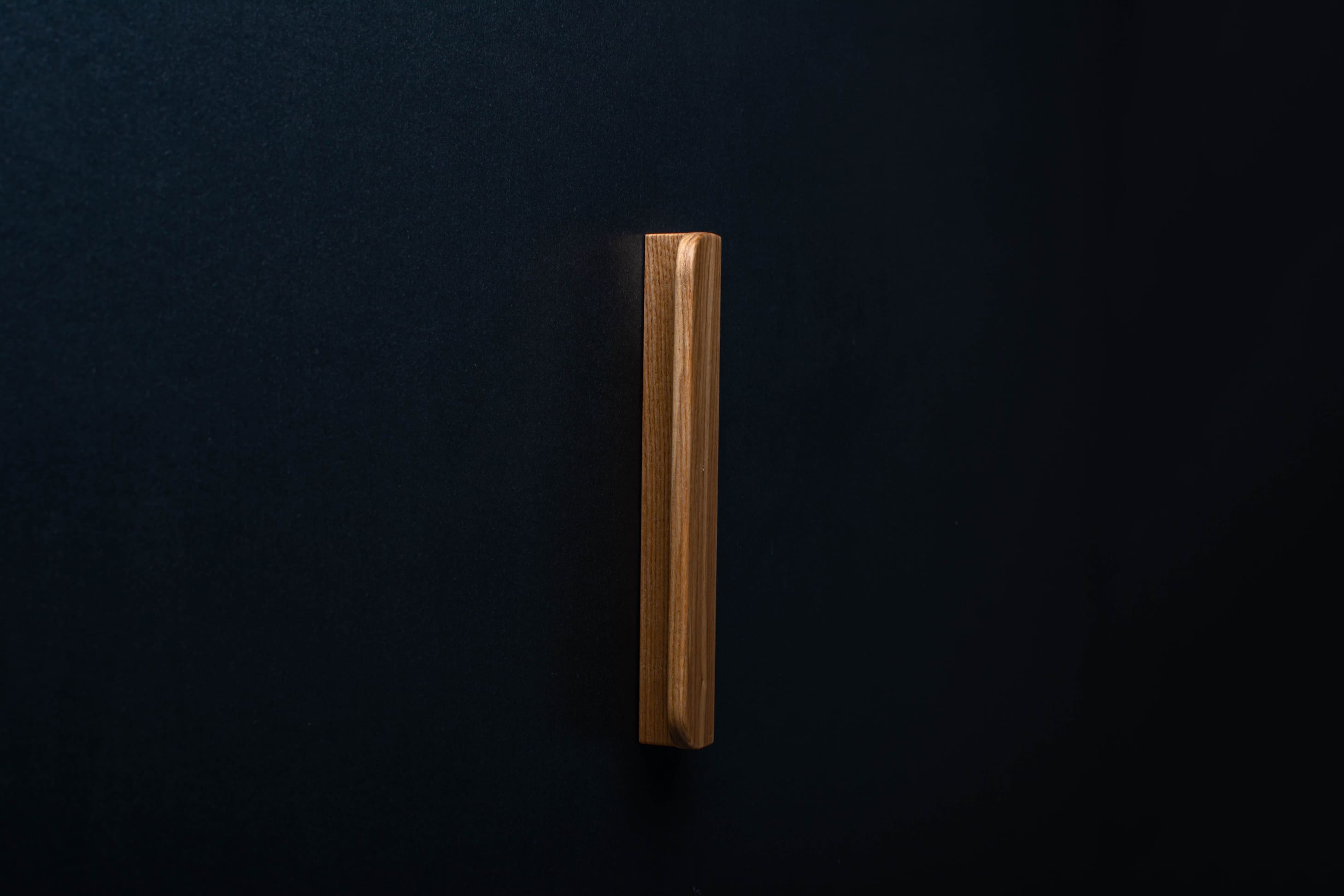 Wooden drawer ash handle in vertical position with detailed view on grip