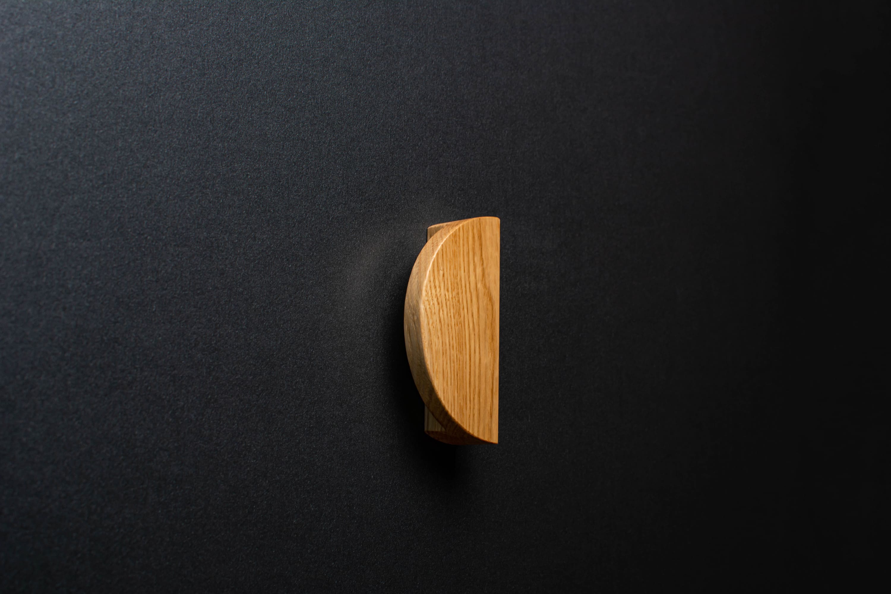 Wooden drawer oak handle in vertical position with detailed view on grip