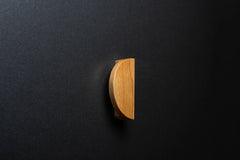 Wooden drawer oak handle in vertical position with detailed view on grip